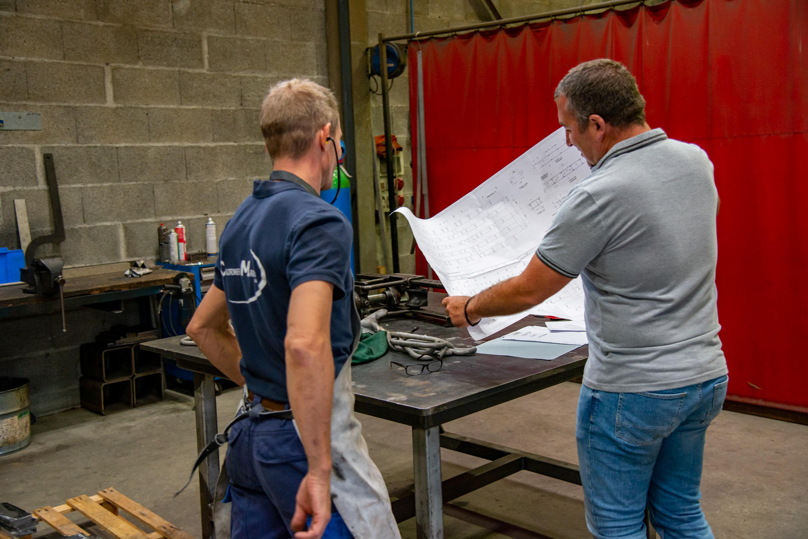 2 employés de la chaudronnerie Marmonier regardant le plan de construction d'un four en inox