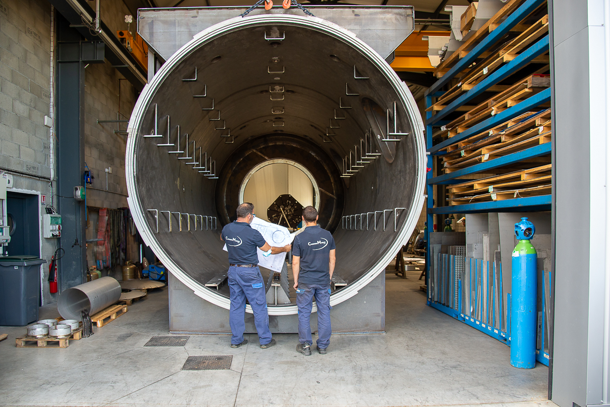 Photo de 2 hommes de la chaudronnerie Marmonier en train d'étudier un plan de conception d'un four industriel sous vide